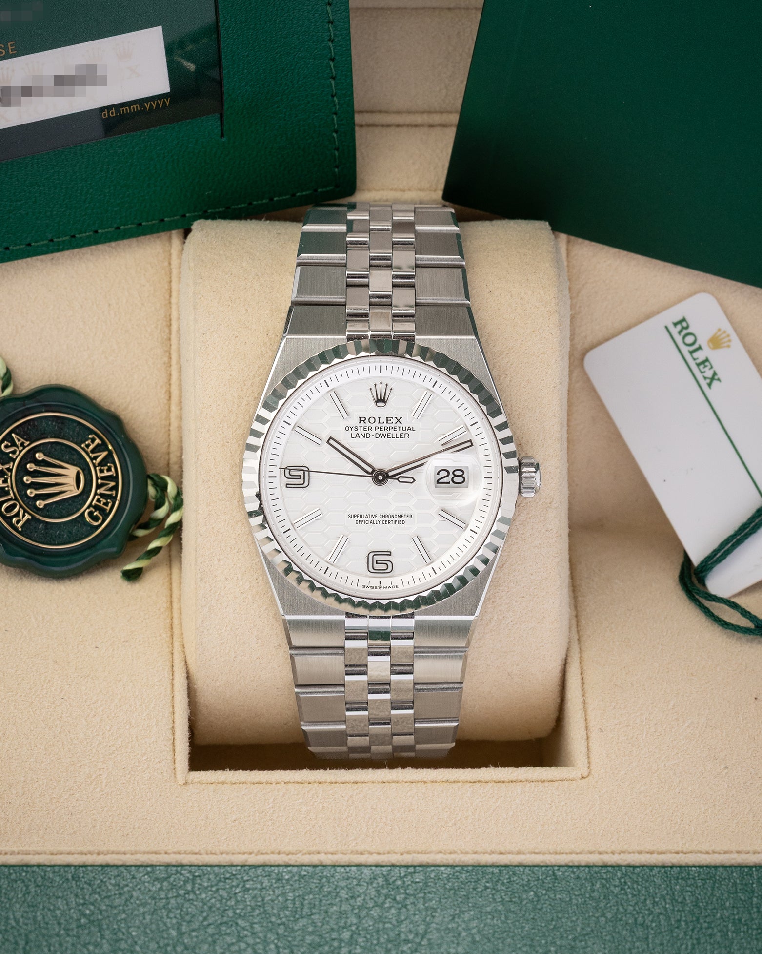A preowned 2025 Rolex Land-Dweller 36 reference 127234 in White Rolesor steel featuring an intense white honeycomb motif dial, fluted bezel, and integrated Flat Jubilee bracelet inside its box at Noah's Fine Watches & Jewelry in Dallas