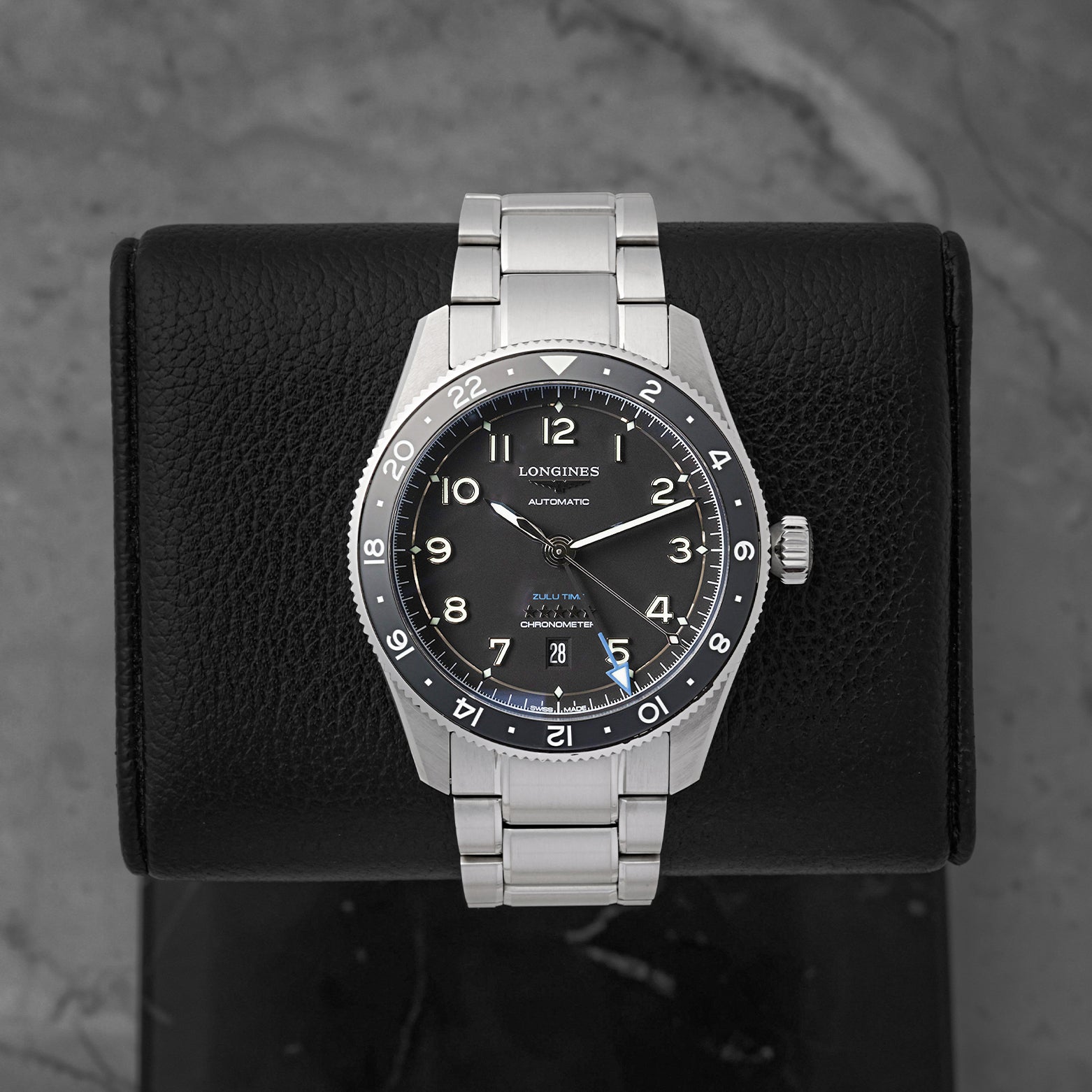 A pre-owned Longines Spirit Zulu Time 42mm reference L3.812.4.53.6 featuring a matte black dial, gilt embossed Arabic numerals, and an independent blue-tipped GMT hand at Noah's Fine Watches & Jewelry in Dallas