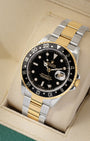 angled view of the 40mm Rolex GMT-Master II 16713 showing the classic black aluminum 24-hour bezel insert, gold GMT hand, and Cyclops date window