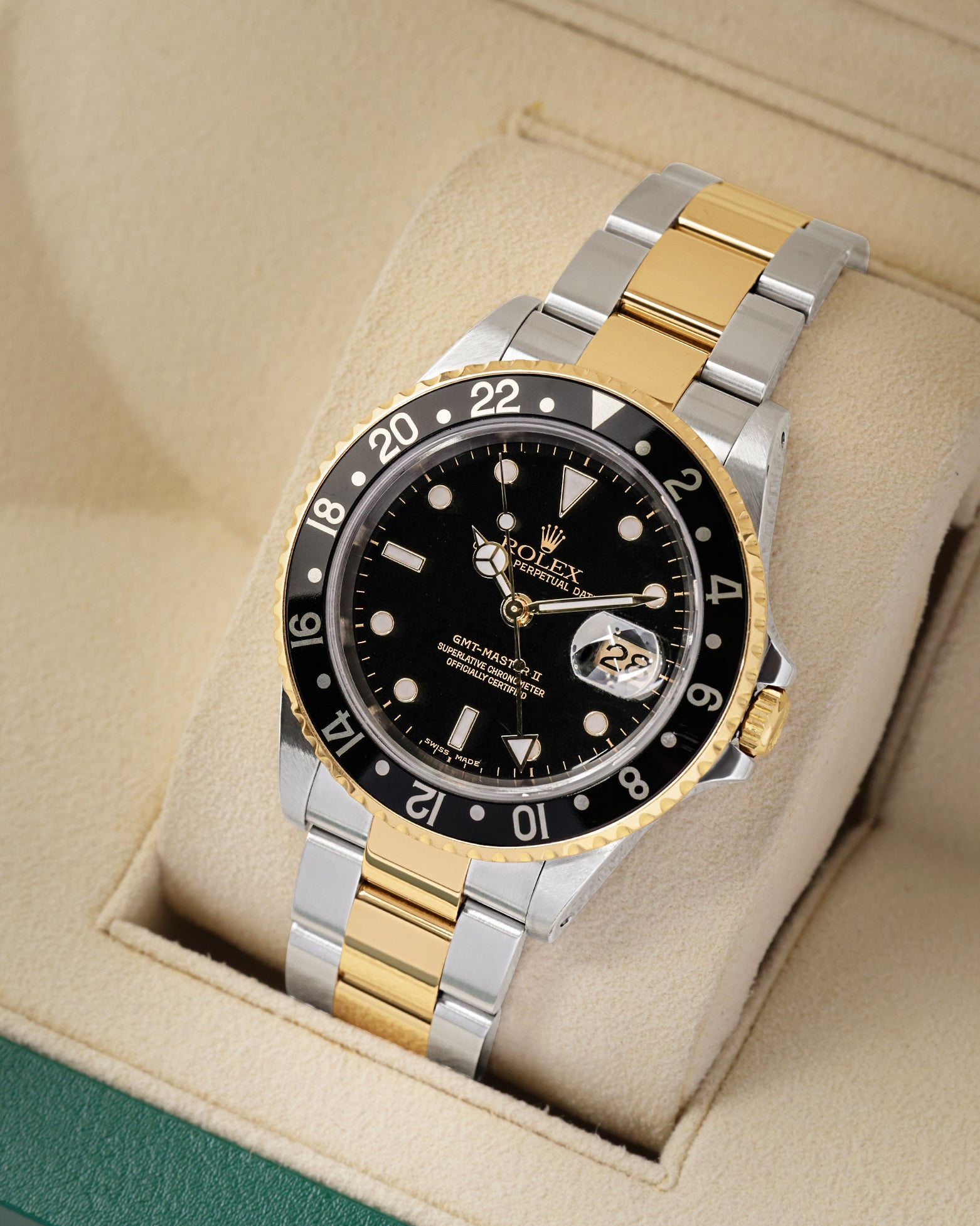 angled view of the 40mm Rolex GMT-Master II 16713 showing the classic black aluminum 24-hour bezel insert, gold GMT hand, and Cyclops date window