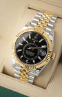 angled view of the 42mm Rolex Sky-Dweller 336933 showing the dual time zone off-center disc, Saros annual calendar, and 18k yellow gold Ring Command bezel