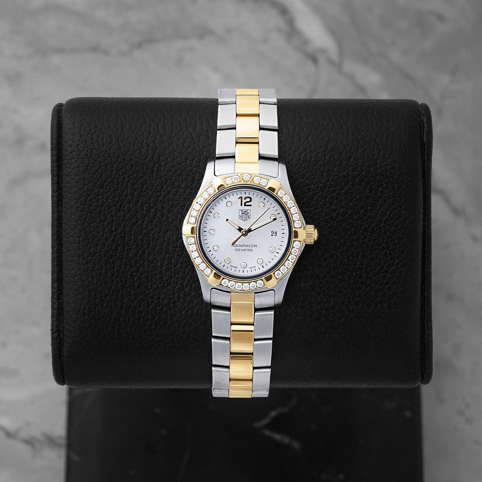 Preowned TAG Heuer Aquaracer 27mm WAF1450 ladies two-tone steel and yellow gold watch with factory diamond bezel and white Mother of Pearl dial at Noah's Fine Watches and Jewelry Dallas Texas