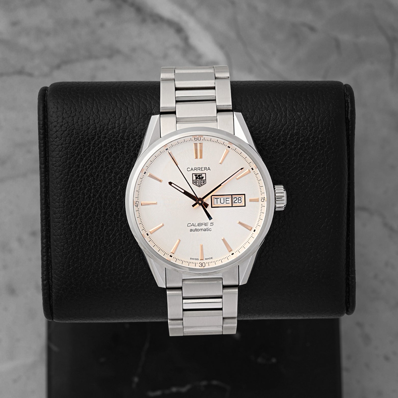 A pre-owned TAG Heuer Carrera Calibre 5 Day-Date reference WAR201D featuring an opaline silver dial, rose gold plated baton indices, and a dual day-date window calendar at Noah's Fine Watches & Jewelry in Dallas