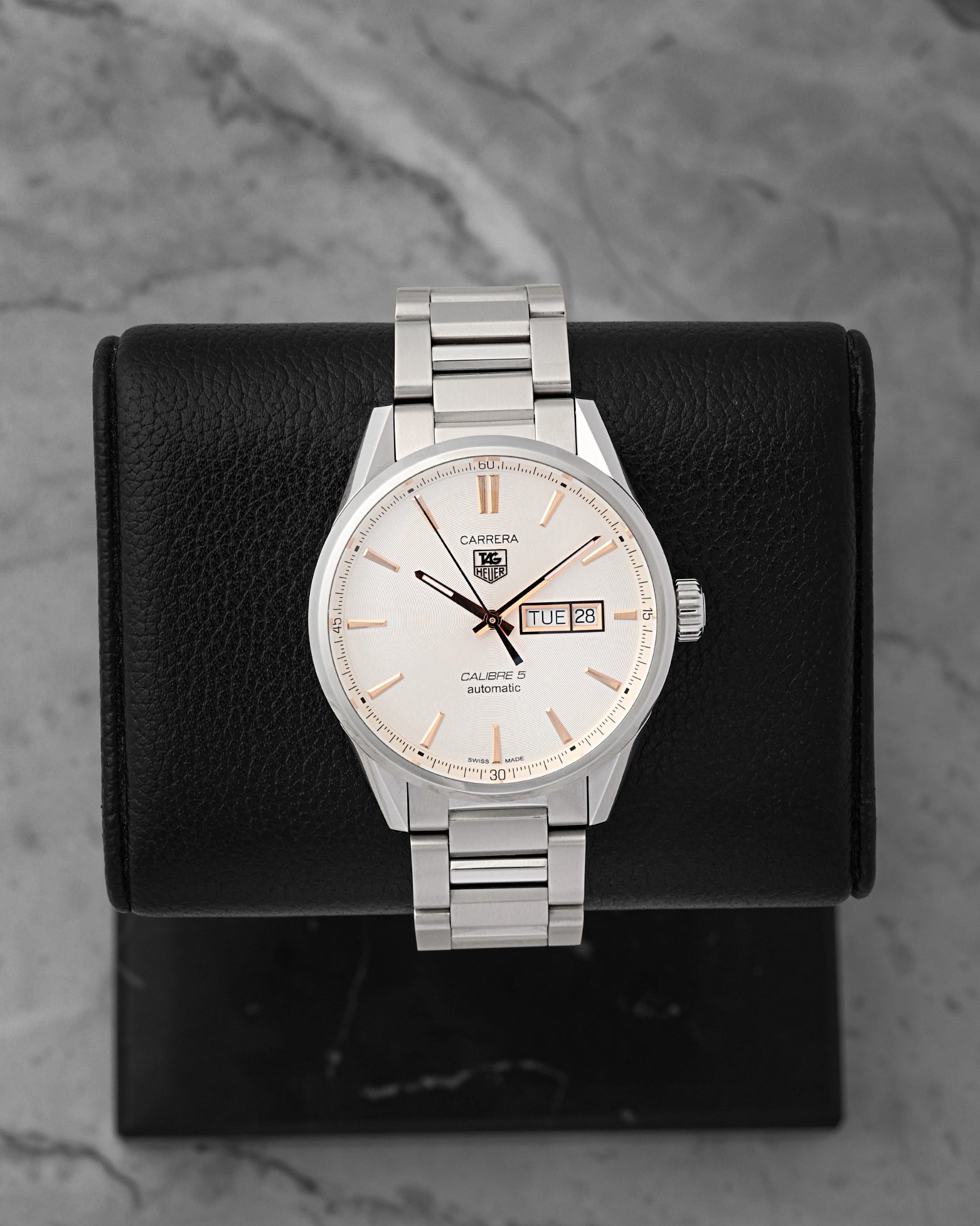 A pre-owned TAG Heuer Carrera Calibre 5 Day-Date reference WAR201D featuring an opaline silver dial, rose gold plated baton indices, and a dual day-date window calendar at Noah's Fine Watches & Jewelry in Dallas