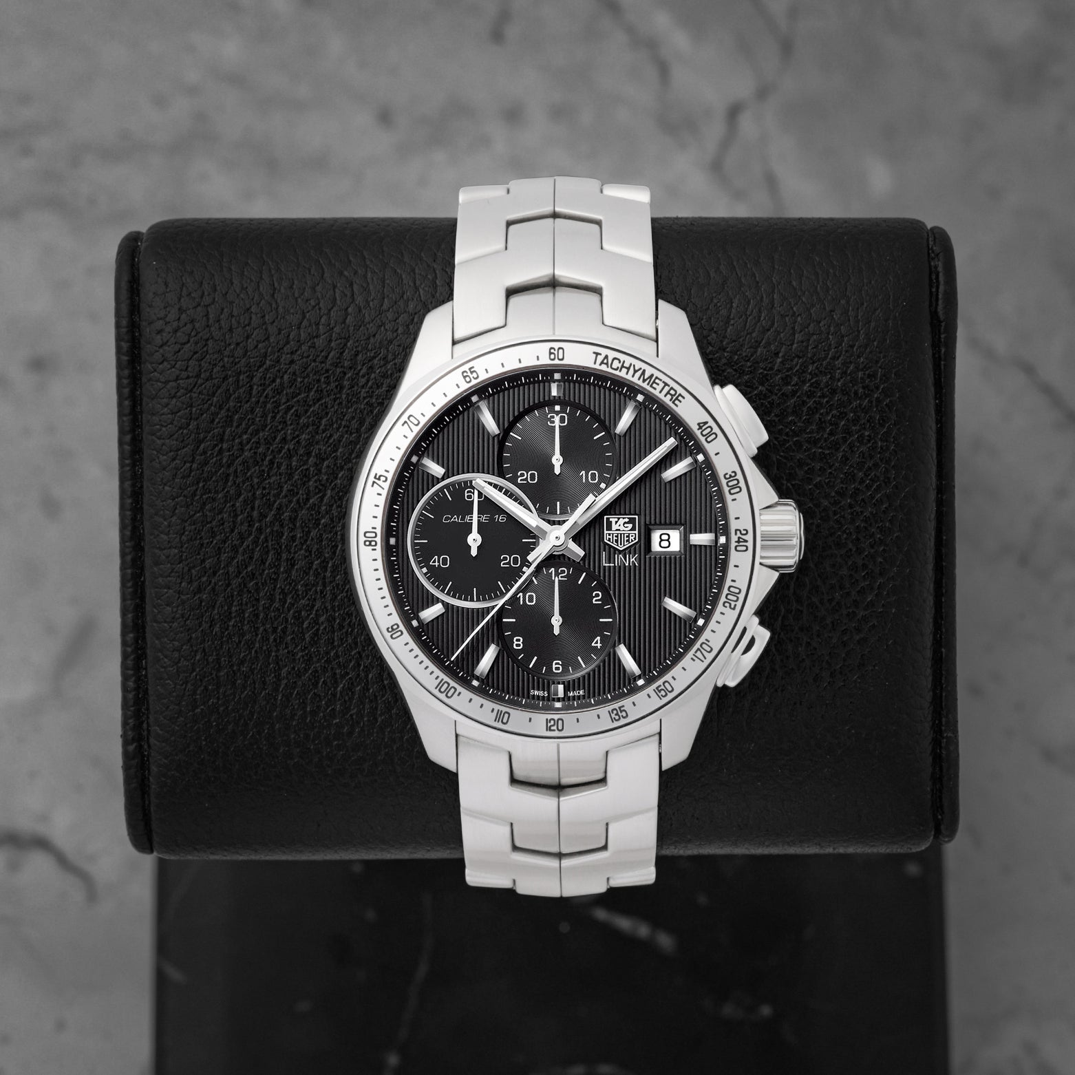 A pre owned TAG Heuer Link Calibre 16 automatic chronograph reference CAT2013 featuring a black dial with vertical textured pinstripes and triple sub-registers at Noah's Fine Watches & Jewelry in Dallas