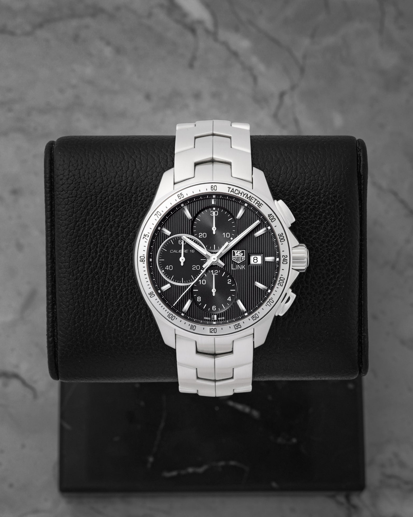 A pre owned TAG Heuer Link Calibre 16 automatic chronograph reference CAT2013 featuring a black dial with vertical textured pinstripes and triple sub-registers at Noah's Fine Watches & Jewelry in Dallas