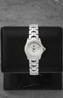 A ladies' pre-owned TAG Heuer Link reference WJF131A featuring an iridescent white mother-of-pearl dial with diamond hour markers and a diamond-set bezel at Noah's Fine Watches & Jewelry in Dallas