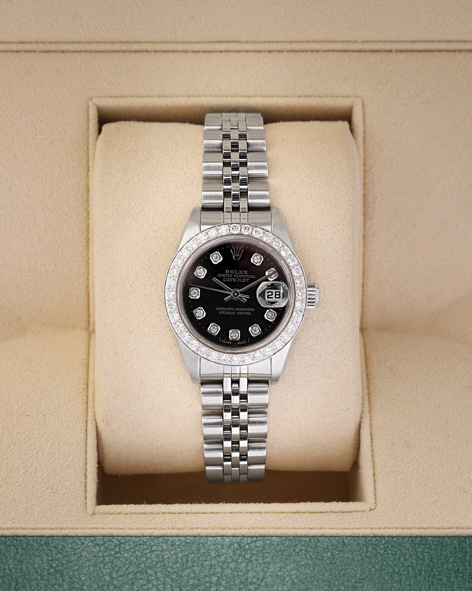 A ladies' pre owned 2000 Rolex Lady-Datejust reference 79174 featuring a custom black dial, diamond hour markers, and a custom diamond-set bezel inside its box at Noah's Fine Watches & Jewelry in Dallas