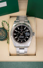 Preowned 2019 Rolex Sky-Dweller reference 326934 in Rolesor steel featuring a black sunray dial, off-center 24-hour GMT disc, and an 18k white gold fluted bezel inside its box at Noah's Fine Watches & Jewelry in Dallas