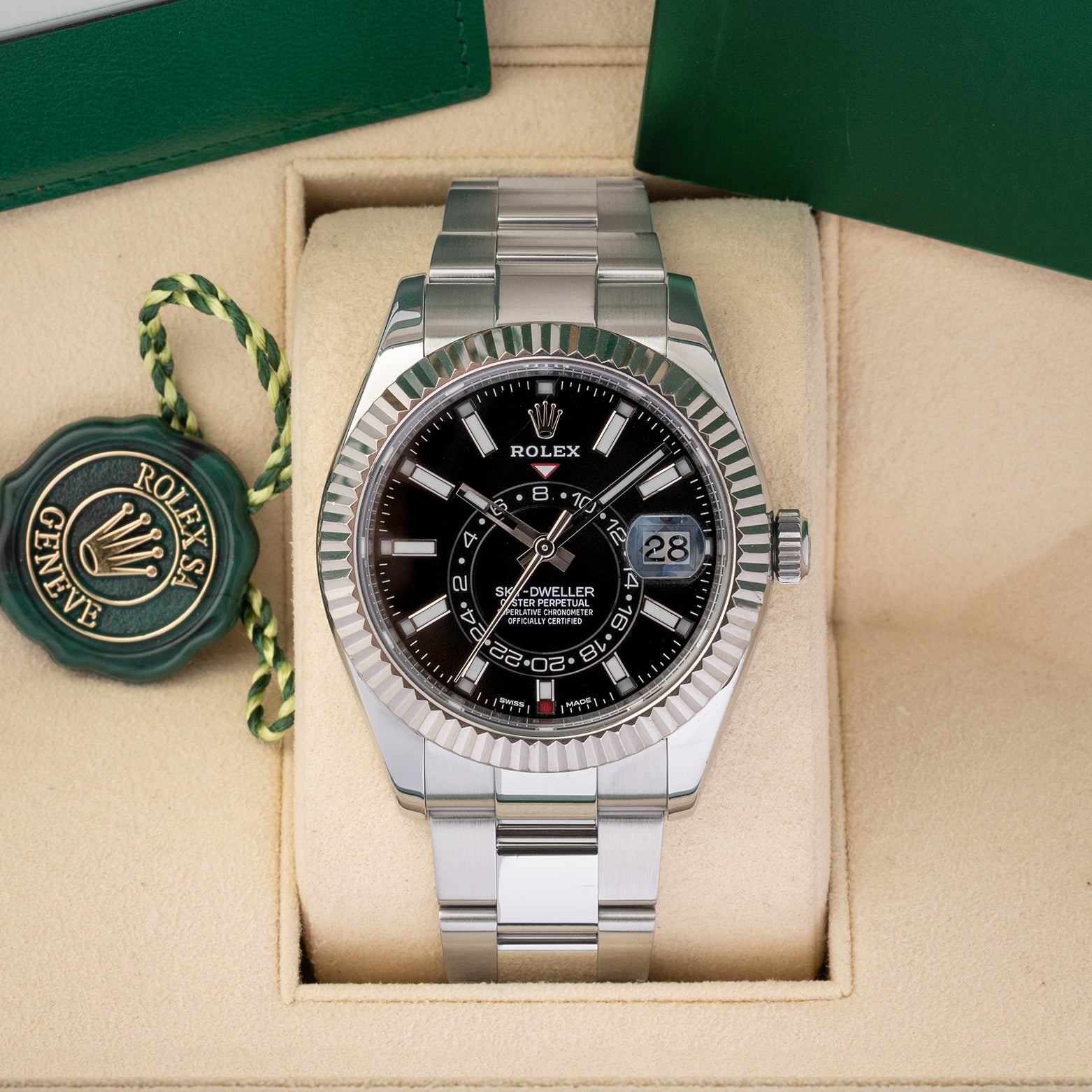 Preowned 2019 Rolex Sky-Dweller reference 326934 in Rolesor steel featuring a black sunray dial, off-center 24-hour GMT disc, and an 18k white gold fluted bezel inside its box at Noah's Fine Watches & Jewelry in Dallas