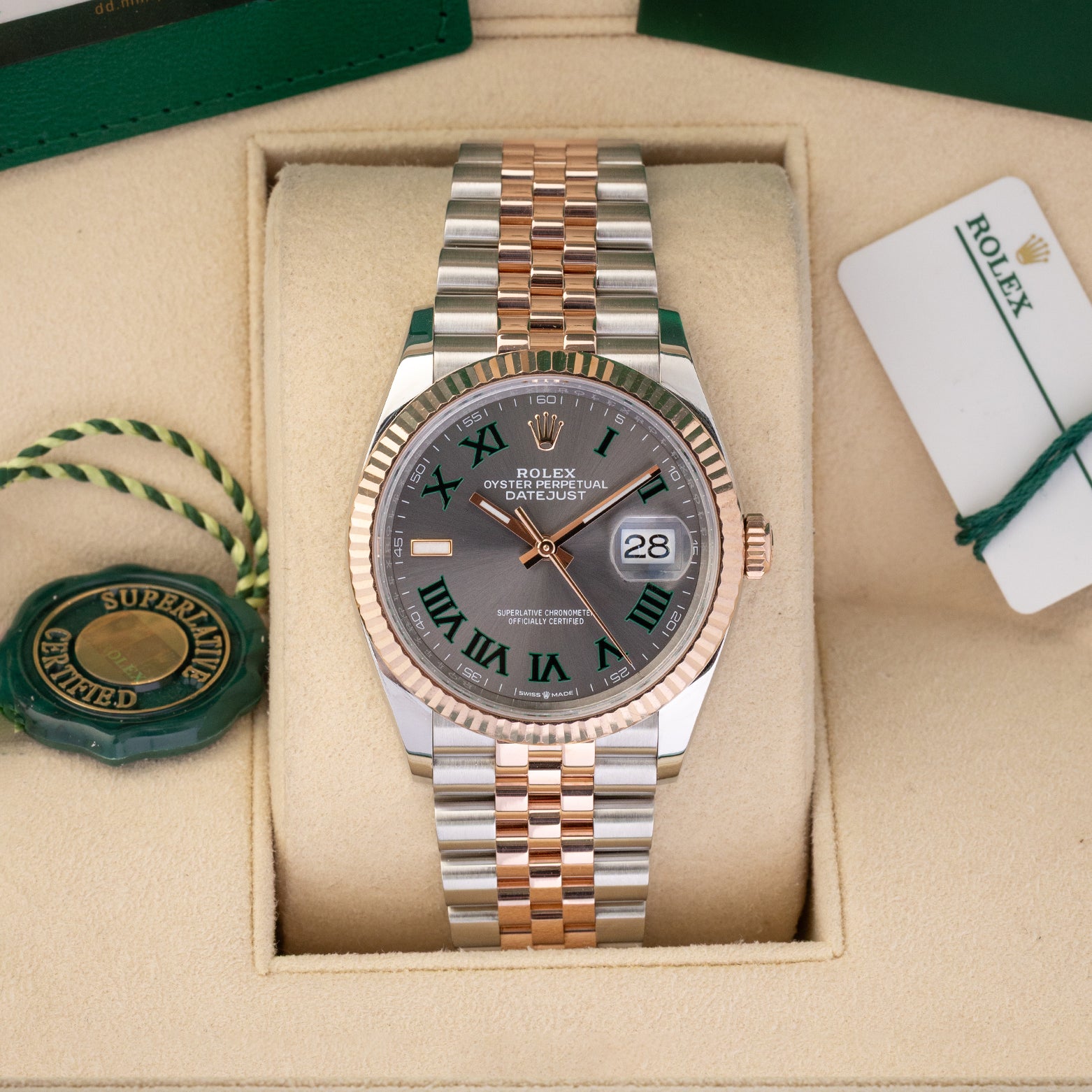 A preowned 2023 Rolex Datejust 36 reference 126231 in two-tone Everose Rolesor featuring a slate Wimbledon dial with green-outlined Roman numeral markers inside its box at Noah's Fine Watches & Jewelry in Dallas