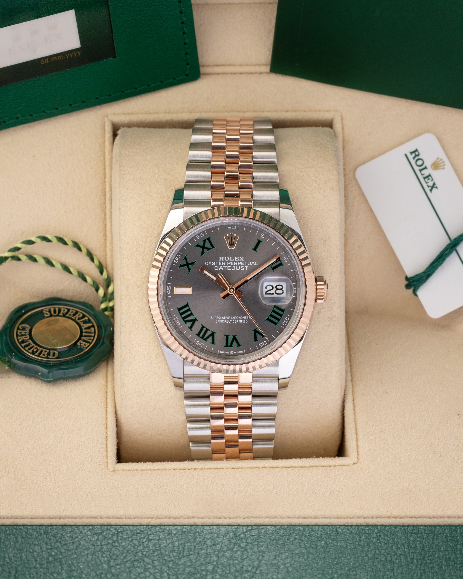 A preowned 2023 Rolex Datejust 36 reference 126231 in two-tone Everose Rolesor featuring a slate Wimbledon dial with green-outlined Roman numeral markers inside its box at Noah's Fine Watches & Jewelry in Dallas