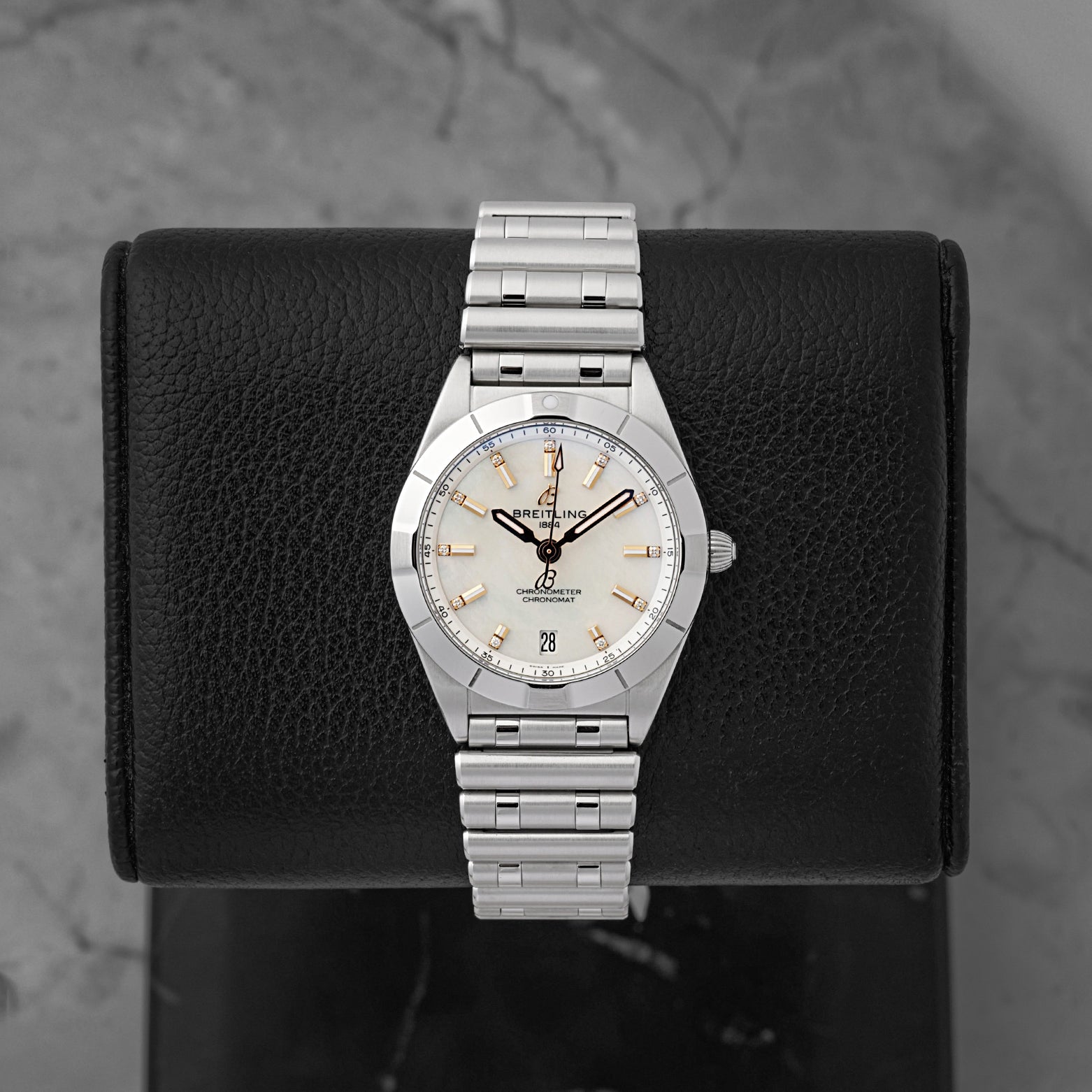 A ladies' pre-owned 2025 Breitling Chronomat 32 reference A77310 featuring a silver sunburst dial, luminous rose gold baton hour markers, and a date window at 6 o'clock at Noah's Fine Watches & Jewelry in Dallas