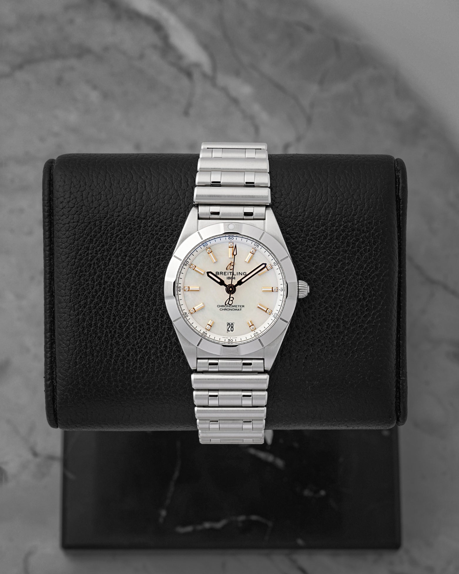 A ladies' pre-owned 2025 Breitling Chronomat 32 reference A77310 featuring a silver sunburst dial, luminous rose gold baton hour markers, and a date window at 6 o'clock at Noah's Fine Watches & Jewelry in Dallas