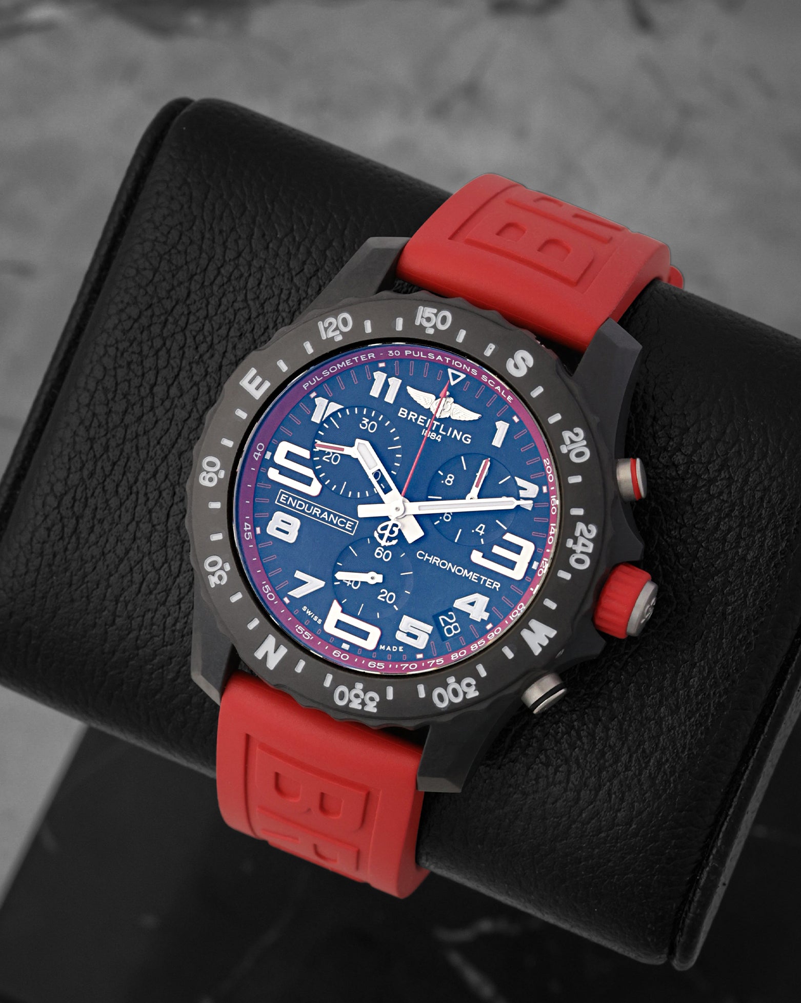 angled view of the Breitling Endurance Pro sports watch showcasing the black chronograph dial, pulse scale inner ring, and prominent white Arabic numerals