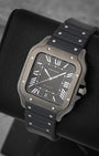 Angled view of the 39.8mm Cartier Santos WSSA0039 showcasing the Roman numeral dial, luminescent sword-shaped hands, and integrated black rubber strap