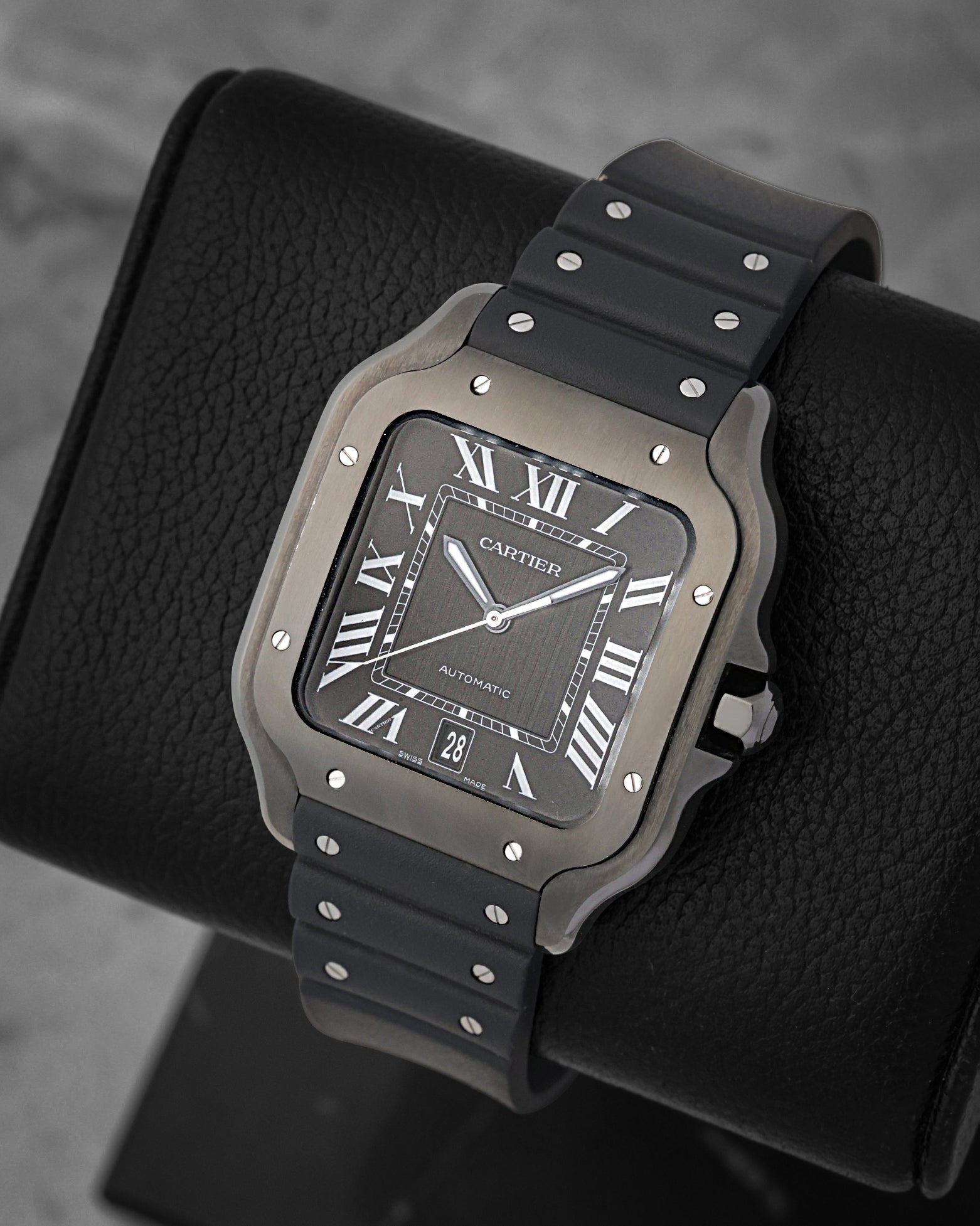 Angled view of the 39.8mm Cartier Santos WSSA0039 showcasing the Roman numeral dial, luminescent sword-shaped hands, and integrated black rubber strap