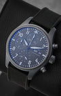 angled view of the 41mm IWC TOP GUN Ceratanium chronograph showing the double-register layout, day-date window, and blue anti-reflective crystal coating