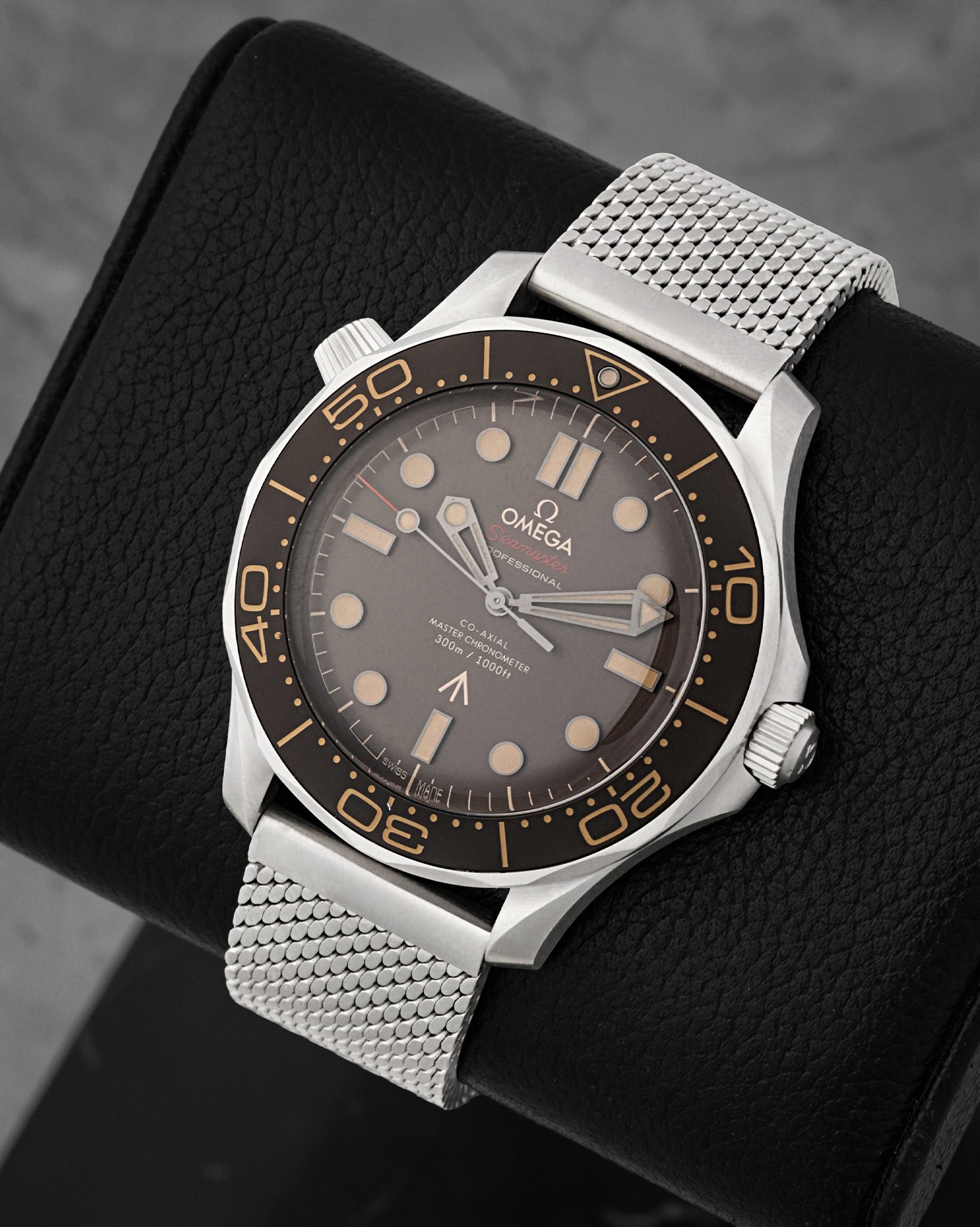 angled perspective of the 42mm Grade 2 Titanium Omega Seamaster NTTD highlighting the matte tropical brown aluminum dial and vintage-style broad arrow marking