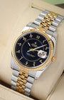 angled perspective of a two-tone Rolex Datejust 36 highlighting the custom blue boiler gauge dial, 18k yellow gold fluted bezel, and steel links