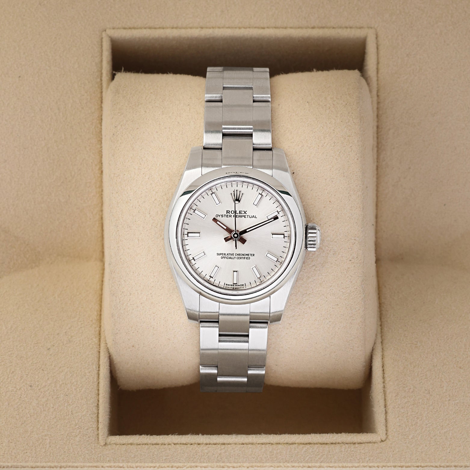 A ladies' pre owned Rolex Oyster Perpetual 26 reference 176200 featuring a silver sunburst dial, luminous baton hour markers, and a smooth domed bezel inside its box at Noah's Fine Watches & Jewelry in Dallas