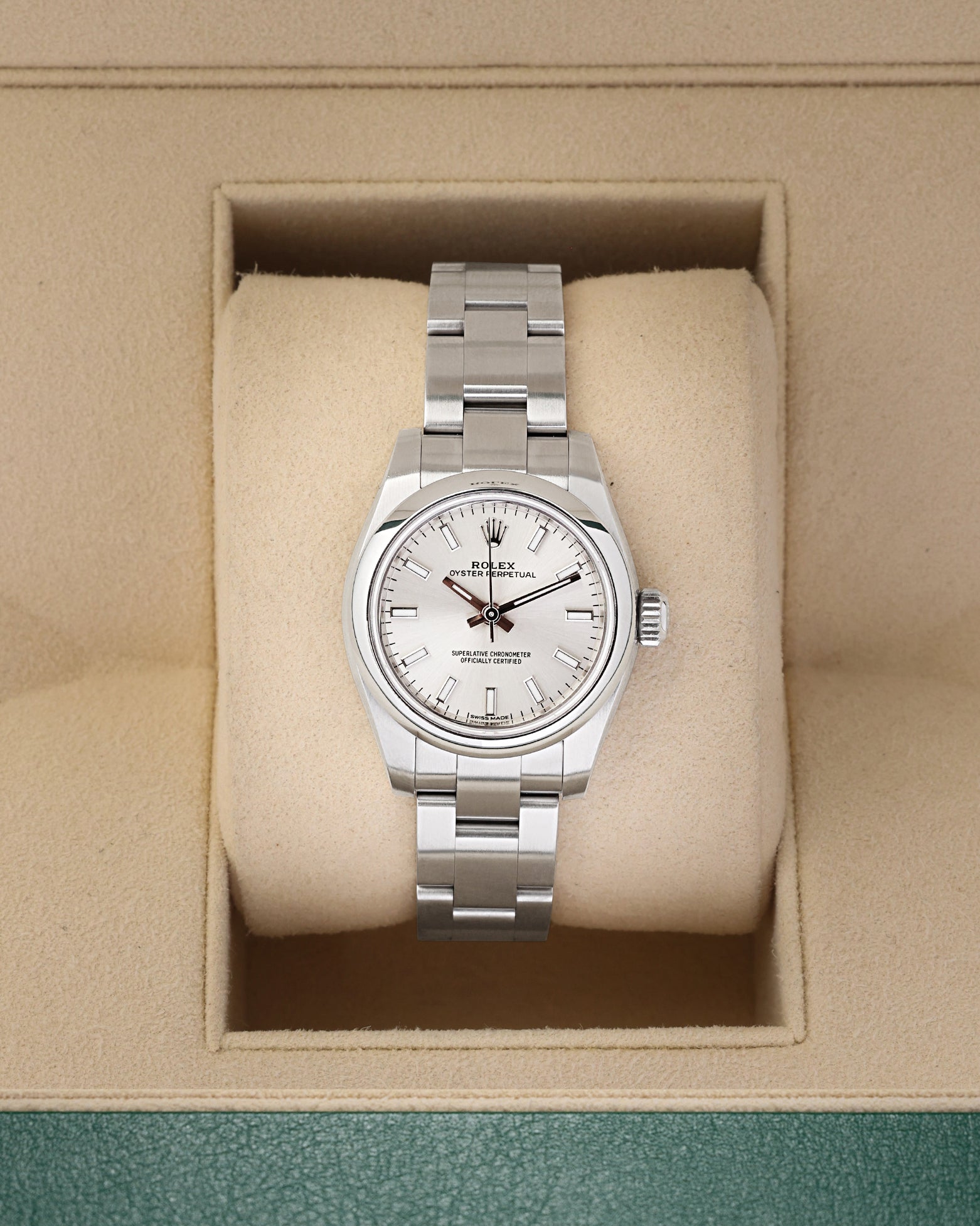 A ladies' pre owned Rolex Oyster Perpetual 26 reference 176200 featuring a silver sunburst dial, luminous baton hour markers, and a smooth domed bezel inside its box at Noah's Fine Watches & Jewelry in Dallas