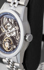Close-up side profile of a brushed steel watch case showing the fluted crown embossed with the RW brand monogram