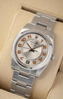 Angled view of pre-owned 2008 Rolex Air-King 114200 featuring a silver concentric circular dial and orange hour markers