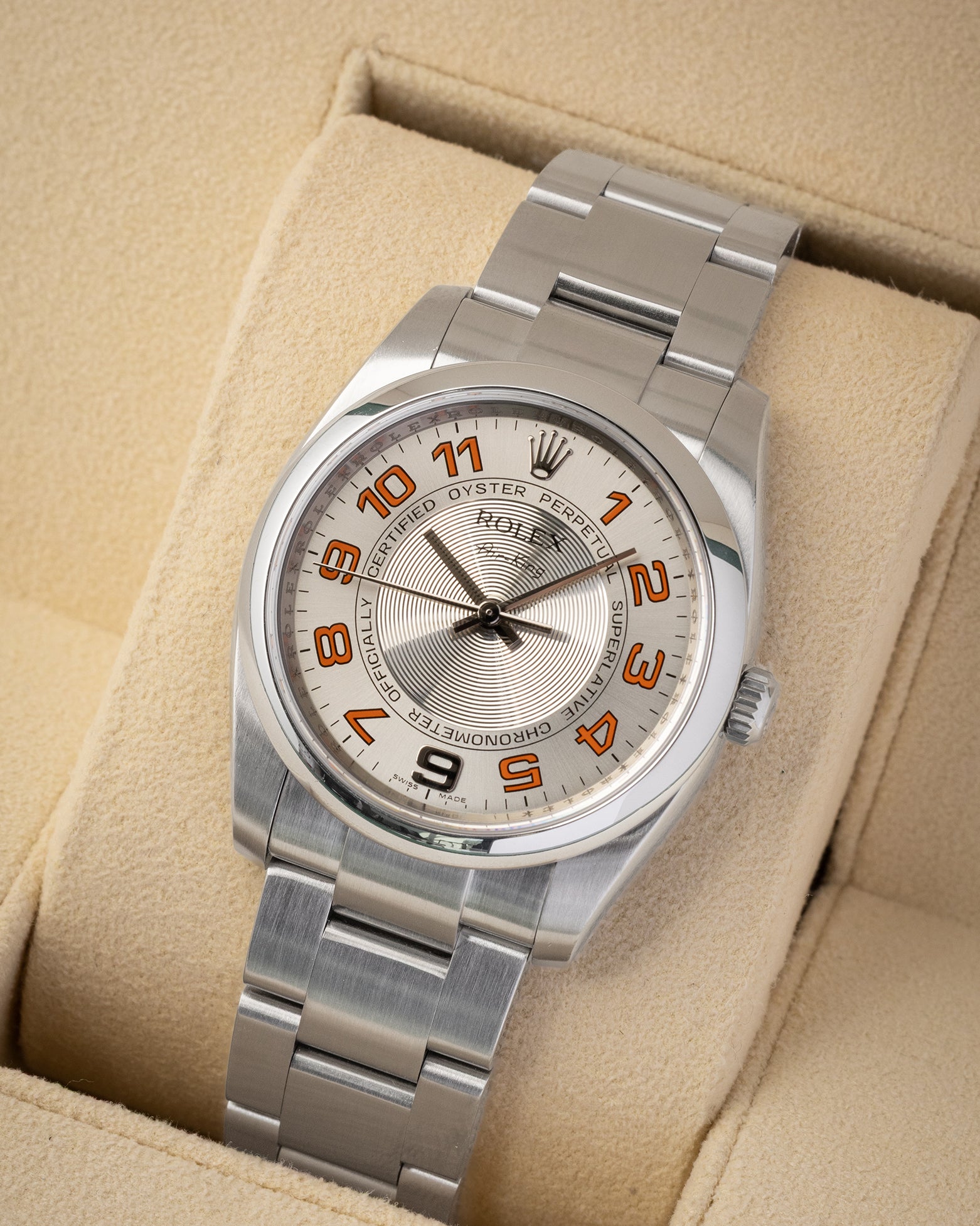 Angled view of pre-owned 2008 Rolex Air-King 114200 featuring a silver concentric circular dial and orange hour markers