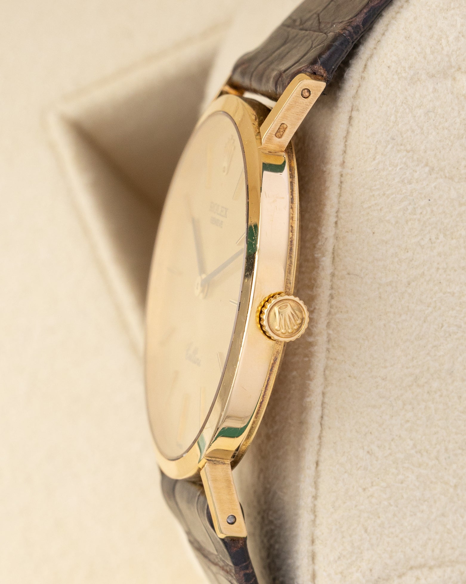 Ultra-thin side profile view showing the 18k yellow gold winding crown and slim case design of a vintage Rolex Cellini 4112