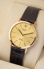 Angled front view of pre-owned 1980 Rolex Cellini 4112 dress watch featuring an 18k yellow gold case, champagne dial, and brown alligator leather strap