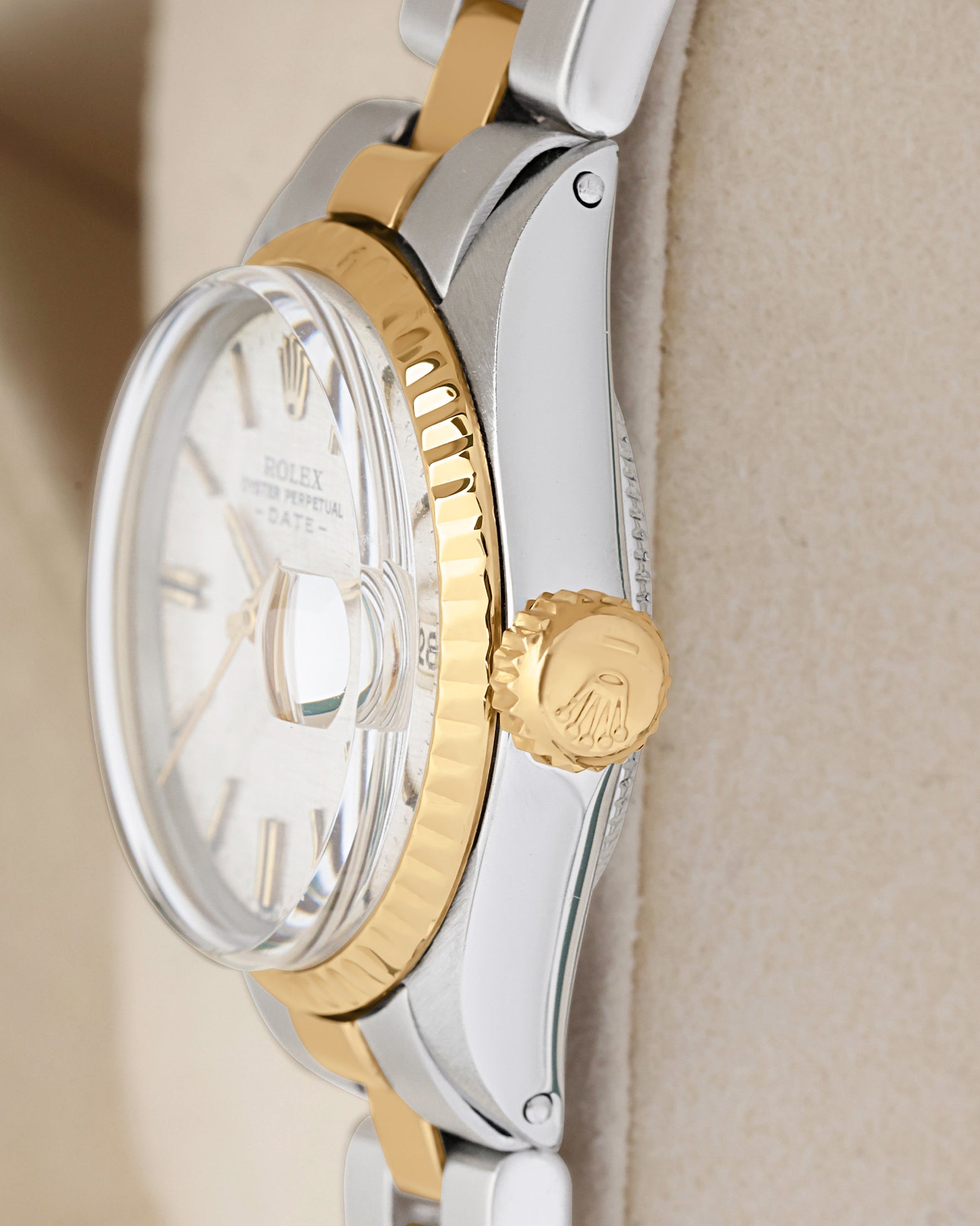 Side profile view of a vintage two-tone Rolex 6517 showing the yellow gold fluted bezel and signed fluted gold screw-down crown