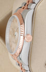 Side profile view of a two-tone Rolex 116231 case showcasing the 18k Everose gold fluted bezel and signed rose gold screw-down crown