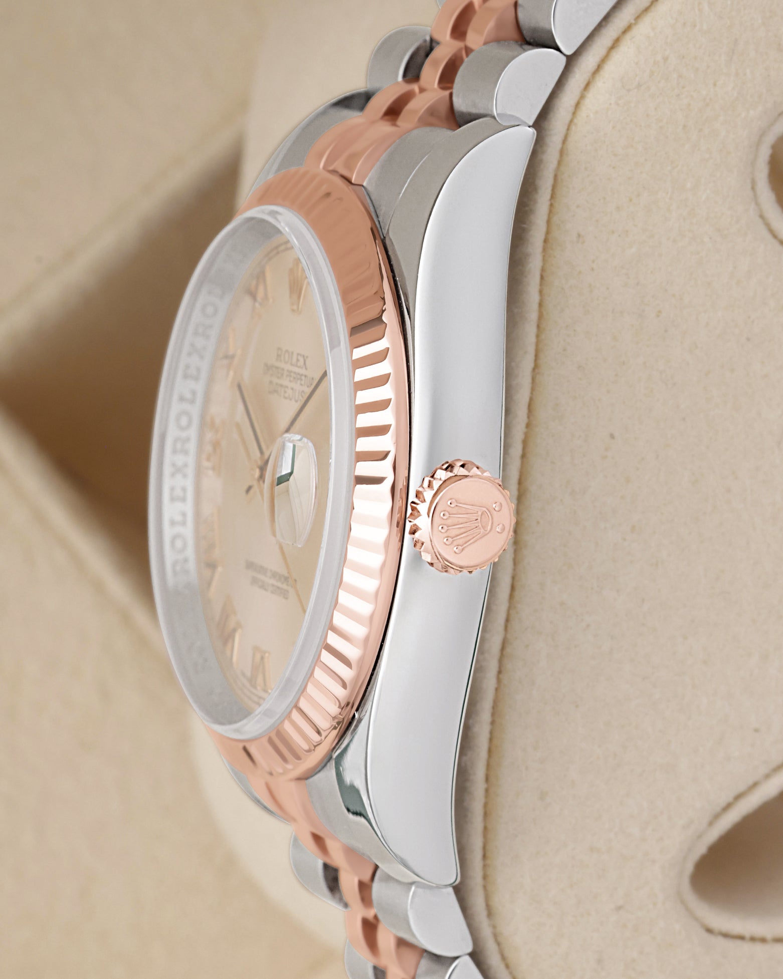 Side profile view of a two-tone Rolex 116231 case showcasing the 18k Everose gold fluted bezel and signed rose gold screw-down crown