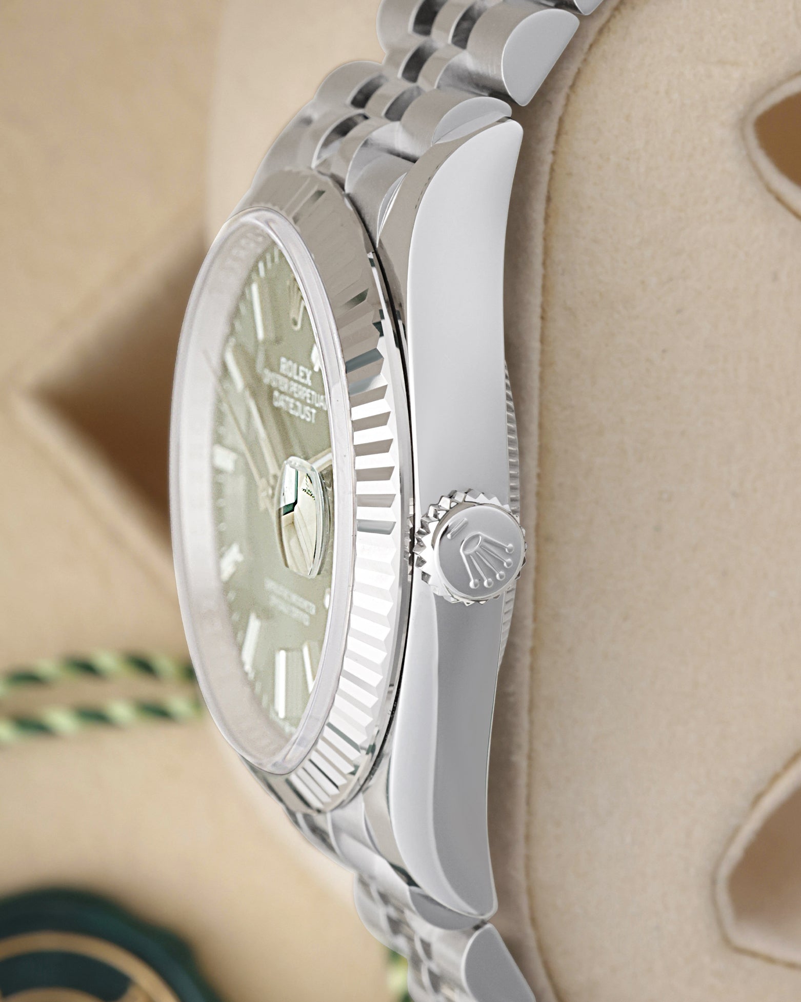 Side profile view of a stainless steel Rolex 126234 case showing the crisp 18k white gold fluted bezel and signed screw-down crown