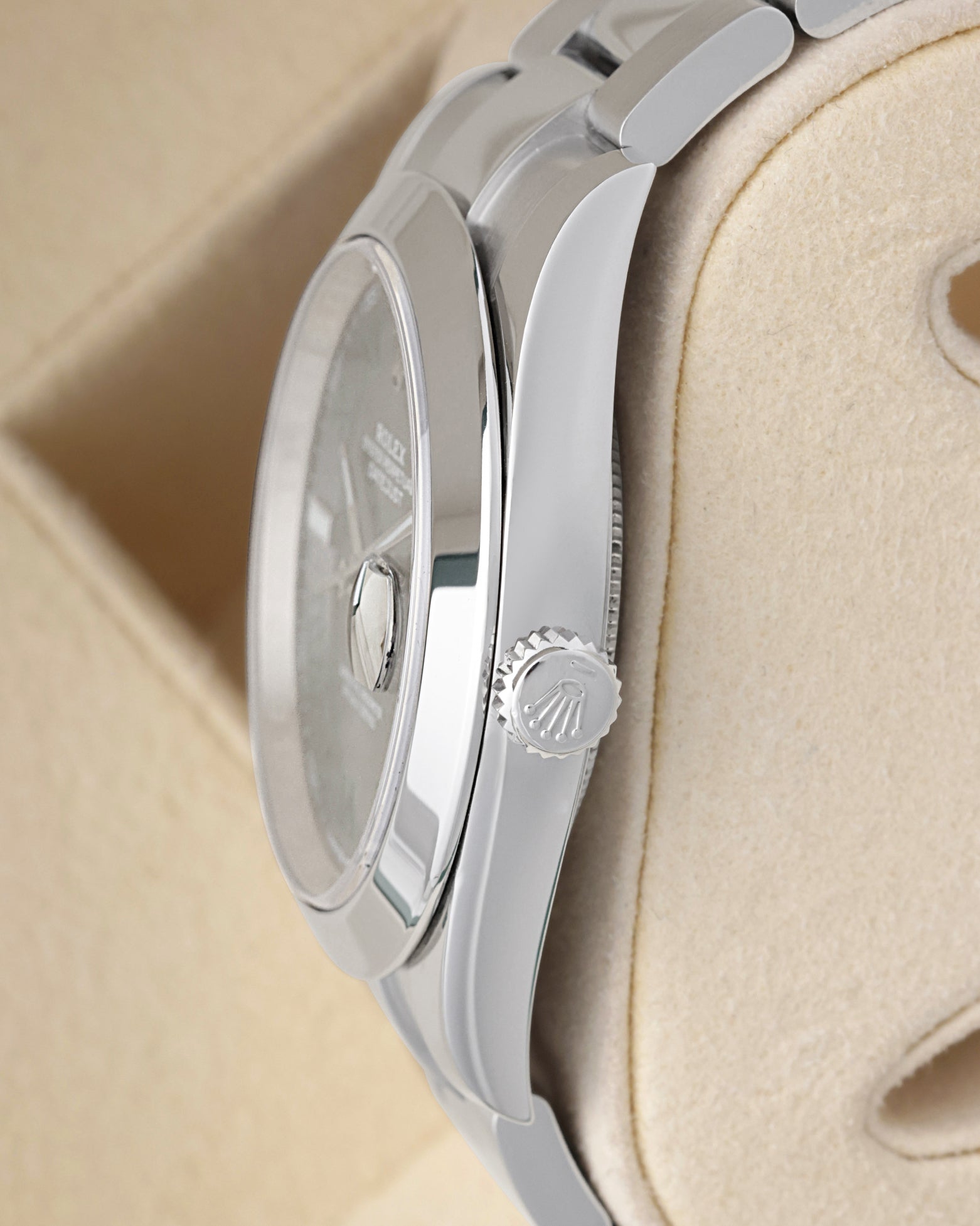 Side profile view of a stainless steel Rolex 126300 case highlighting the polished smooth bezel and signed Twinlock screw-down crown