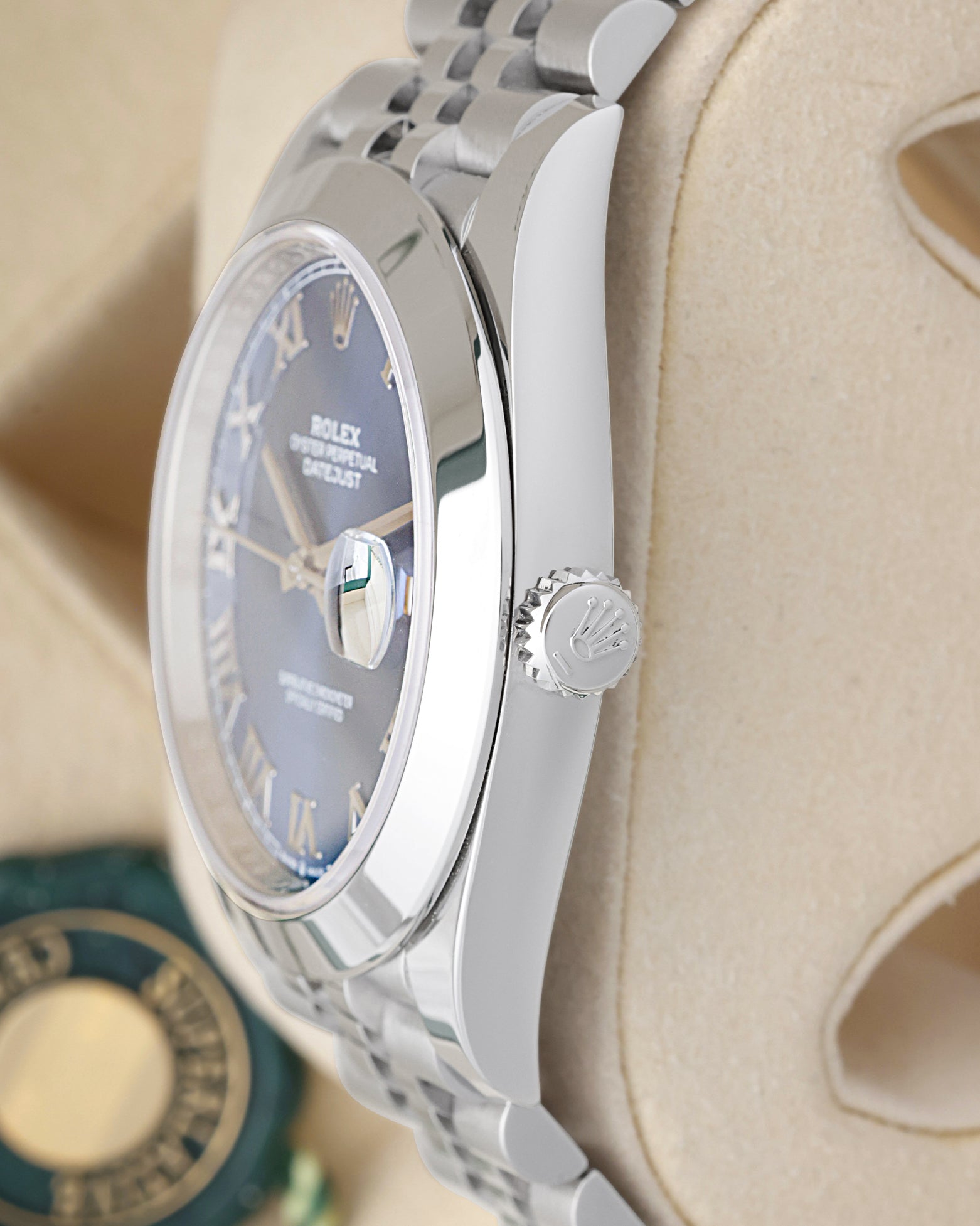 Side profile view of a stainless steel Rolex 126300 case showing the polished smooth bezel and signed Twinlock screw-down crown