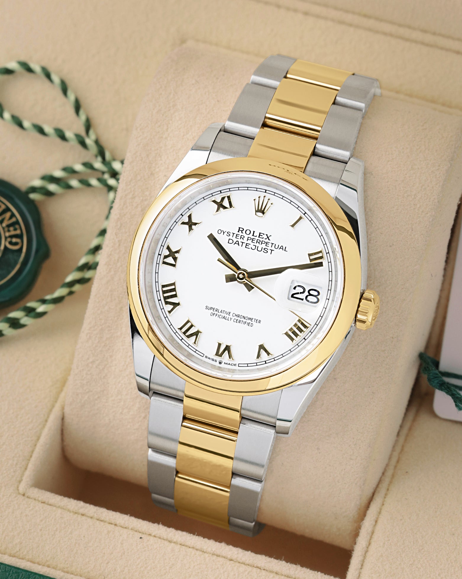 angled view of Rolex Datejust 36 126203 featuring a white dial, 18k yellow gold Roman numerals, and Oyster bracelet