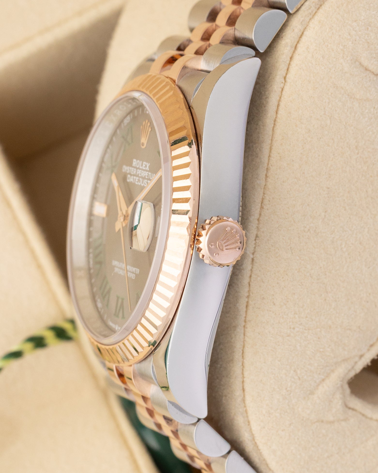 Close-up right profile view of the watch head highlighting the sharp coin-edge fluted bezel details, flat sapphire crystal with Cyclops lens, and the 18k Everose gold Twinlock crown