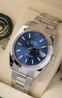angled top-down studio view of the stainless steel Rolex Datejust 41 blue dial watch resting on a cream leather watch pillow