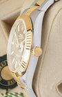 Close-up of the 18k yellow gold Twinlock winding crown and fluted bezel on a Rolex Datejust 41