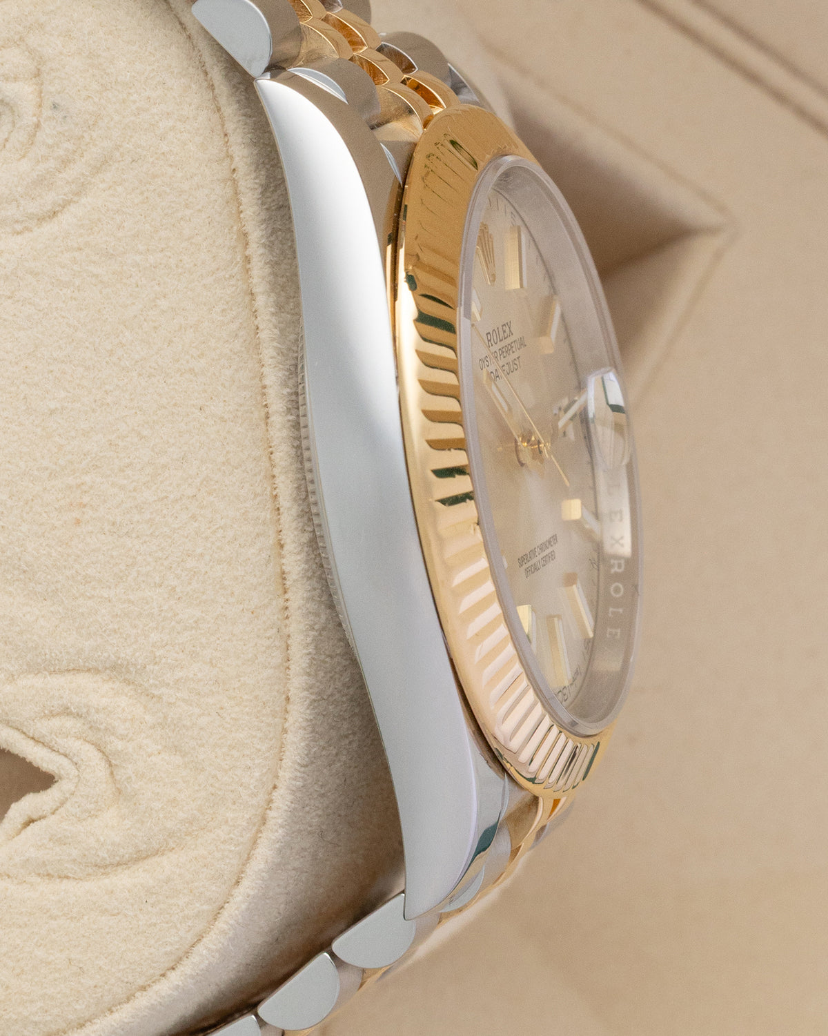Polished steel case profile and fluted gold bezel view of pre-owned Rolex Datejust 41 on presentation pillow