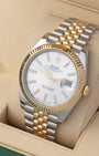 Angled view of Rolex Datejust 41 126333 featuring silver stick dial, 18k yellow gold fluted bezel, and two-tone Jubilee bracelet