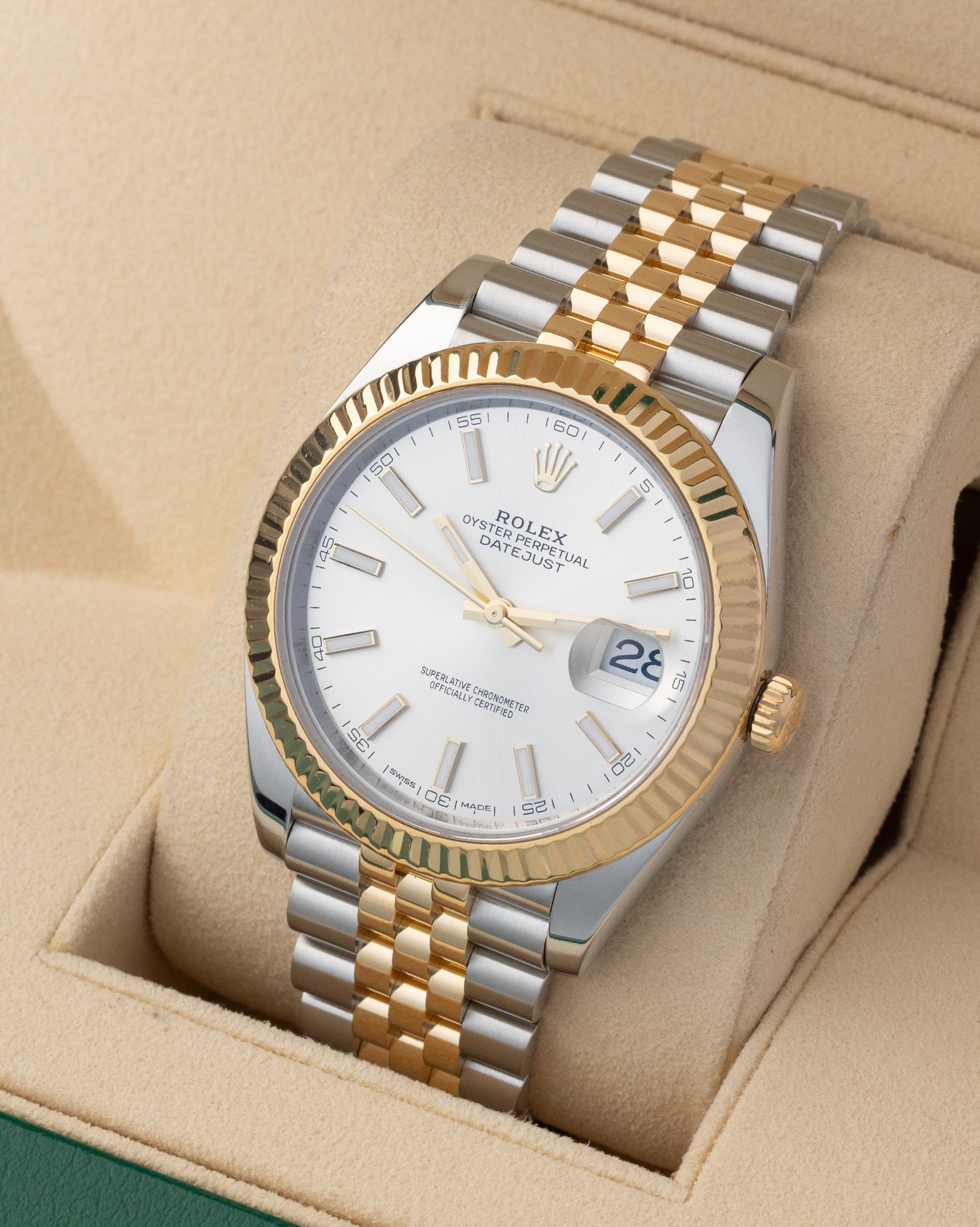 Angled view of Rolex Datejust 41 126333 featuring silver stick dial, 18k yellow gold fluted bezel, and two-tone Jubilee bracelet