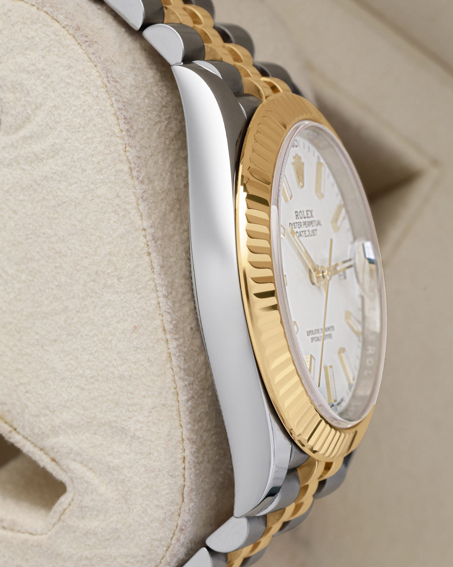 left-side case profile view of a pre-owned steel and 18k yellow gold 41mm Rolex Oyster case resting on a presentation cushion
