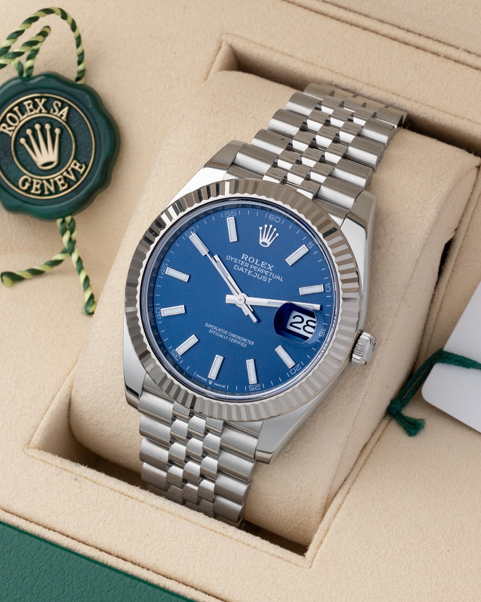 Angled view of Rolex Datejust 41 126334 featuring bright blue dial, fluted white gold bezel, and green tag
