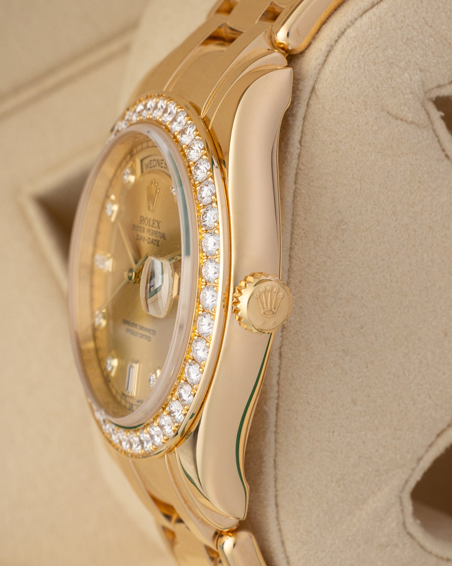 Close-up right profile view of the heavy gold watch head highlighting the smooth profile of the sapphire crystal, brilliant diamond settings, and the fluted 18k yellow gold Twinlock winding crown