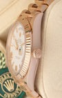 Close-up right profile view of the watch head focusing on the sharp coin-edge fluted bezel details, flat sapphire crystal, and the 18k Everose gold Twinlock winding crown
