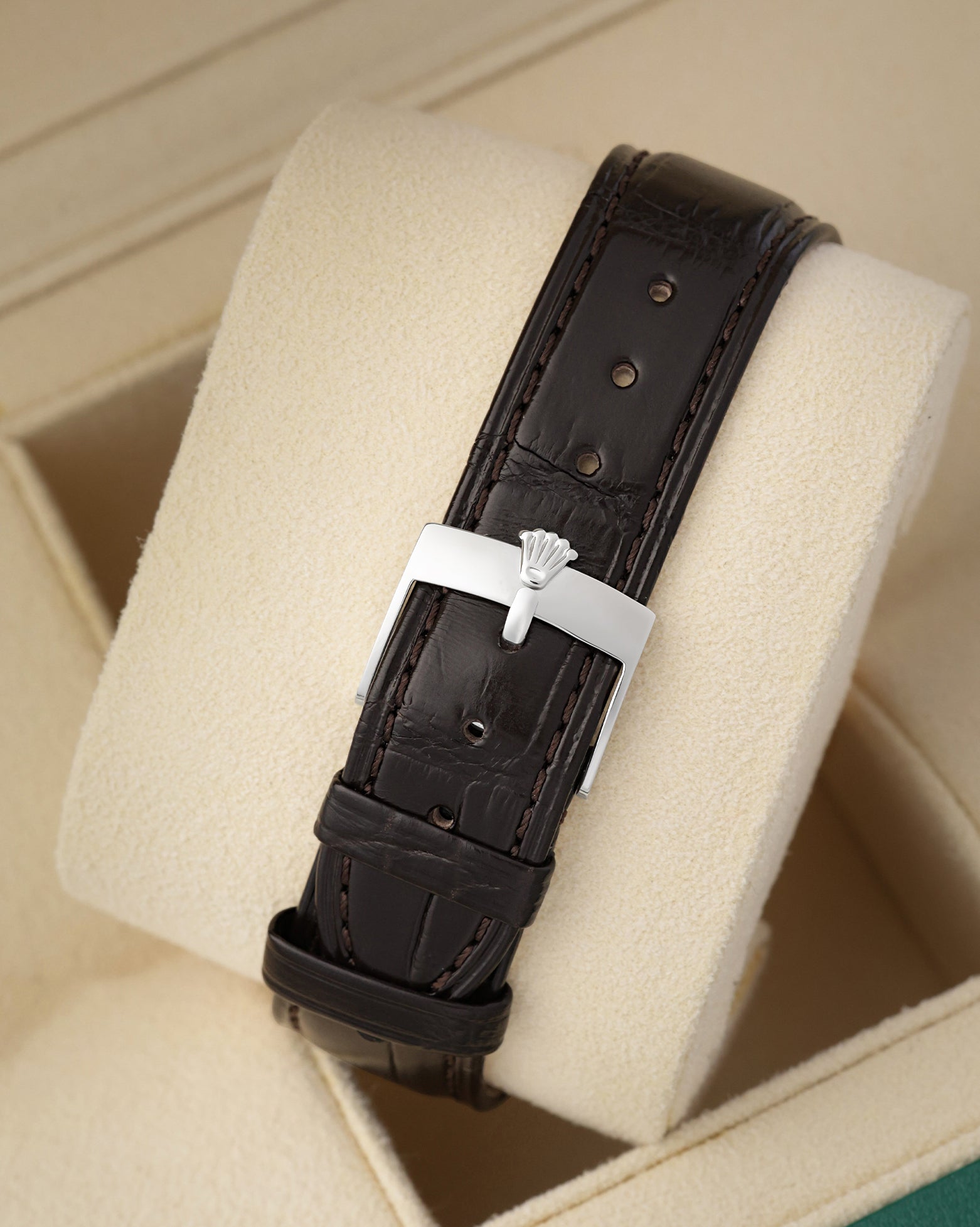 Rear view of the dark brown alligator grain leather strap secured with a polished steel tang buckle on the vintage Rolex watch