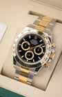 Angled view of preowned Rolex Cosmograph Daytona reference 126503 featuring an 18k yellow gold tachymeter bezel and black dial.